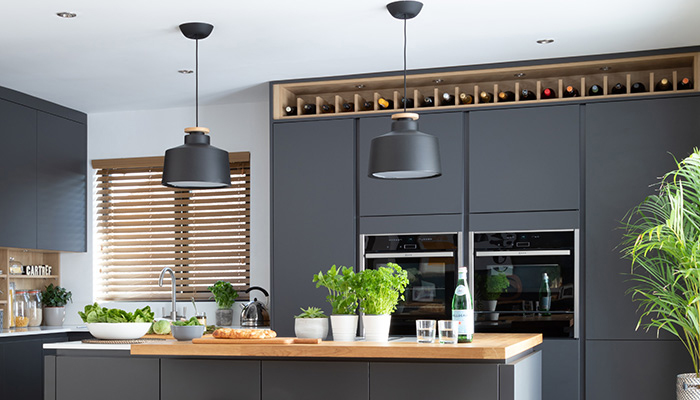 An open wine rack above tall cabinetry in this Masterclass Kitchens design utilises the space in a beautiful and functional way
