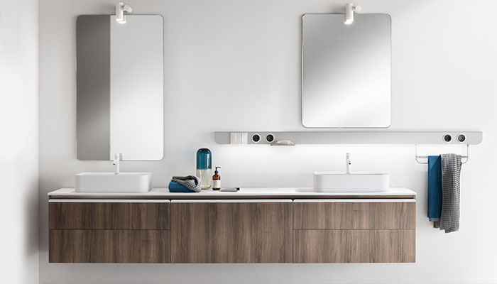 In this Dandy Plus bathroom, the aluminium Task Bar with smart speaker has a soap dish and towel rail suspended from it. The vanity is Oak veneer with Prestige White handles