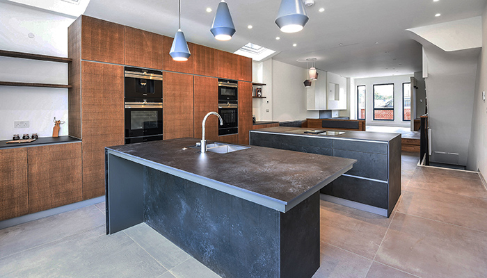 Coliseum Oxide Black matt porcelain slab tiles, shown here clad onto the cabinetry, and on the kitchen worktop