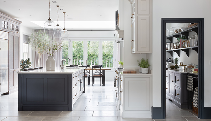 This long walk-in pantry by Humphrey Munson was designed to run the length of the main cooking area and provide a space for food storage but also act as a scullery area when entertaining. Cabinets in Bowler Black give a bold look with eye-catching aged brass hardware