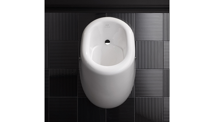 The Liquid urinal, shown against black wall tiles from the collection