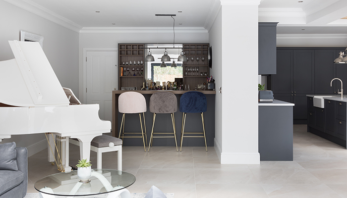 This bespoke home bar, designed to sit alongside the Masterclass Shelford Graphite kitchen, provides a dedicated entertainment area in an open plan space. Tuscan Walnut shelving allows the client to present bottles in style, and the peninsular island acts as the perfect counter to serve guests