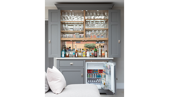 The drinks bar at this Worcestershire project by Humphrey Munson was designed to have countertop space for preparing drinks, with an under-counter fridge that also has a freezer section for storing ice. Photo by Paul Craig