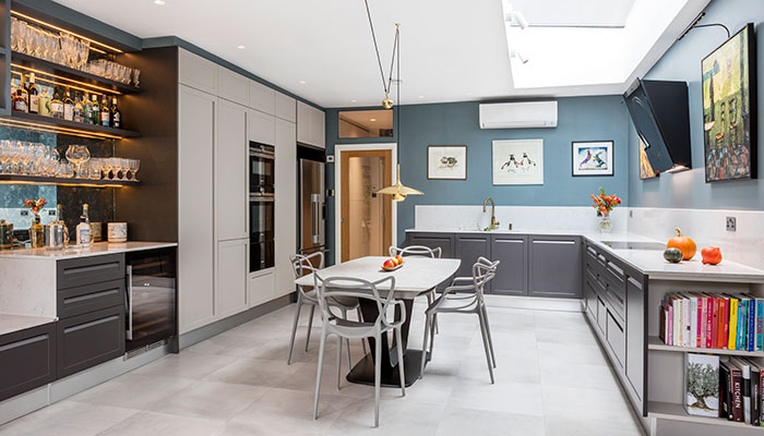 This bar area was used to bridge the kitchen and dining areas of this space and make them a seamless continuation of one another. The furniture is Scavolini’s Carattere collection in Iron and Light Grey matt lacquer with worktops and splashbacks in Quartforms Imperial White. In the bar area, antique mirror has been used behind the illuminated shelves
