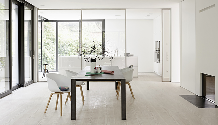 Utilising floor-to-ceiling framed glass panels to separate the kitchen from dining areas, this handleless Eggersmann design centres around an island from the UNIQUE range, dressed to impress in Glacier White solid Corian, with wall units from the E3.0 range in Karat matt lacquer