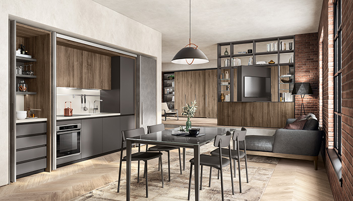 Panelled doors in Oxide Steel melamine neatly conceal the kitchen when not in use in this flexible living space featuring Scavolini’s BoxLife collection. Helping to divide the room, Fluida open shelving in Garden Walnut and Iron Grey melamine features a revolving panel that allows the TV to be viewed from both sides