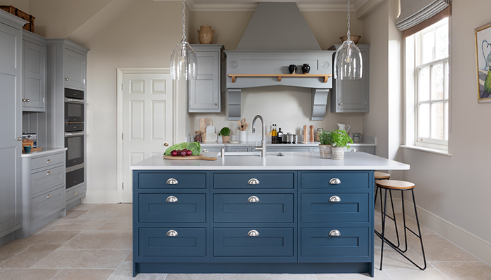Hand-painted in Farrow & Ball Manor House Grey, the cabinetry in this Signature Bespoke kitchen by Searle & Taylor provides the perfect neutral backdrop to the rich Hague Blue island, which adds a pop of colour