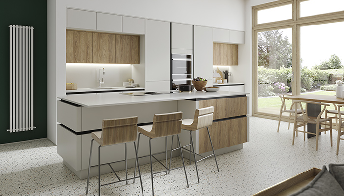 Wooden accents inject warmth to this cool and contemporary open-plan, handleless design from Masterclass Kitchens, which combines H Line Sutton units in Scots Grey with Madoc Portland Oak