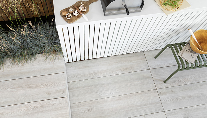 CTD Tiles’ Oaktime Milk glazed porcelain outdoor tiles provide a practical and stylish flooring option for this open air kitchen