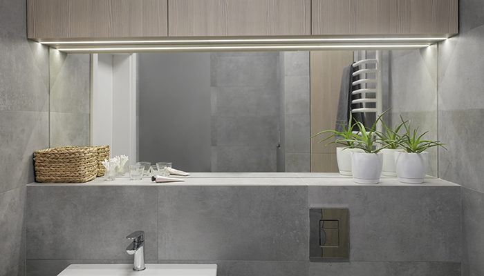 Recessed LED aluminium profiles – available as bespoke lengths from TLW – are shown here fitted into bathroom cabinetry, providing illumination above the sink that is both stylish and practical