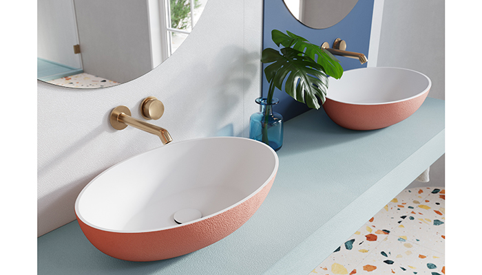 Featuring oval lines, Acquabella’s On-Top countertop basin features a white interior and textured Beton exterior in Coral Glow