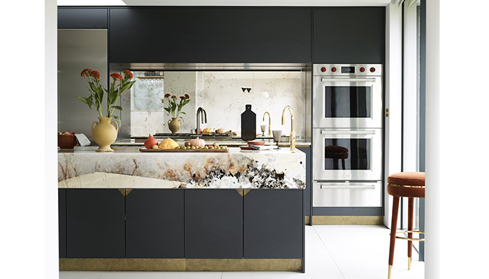 Echoing a triangle theme throughout the entire property, this bespoke kitchen by Roundhouse showcases its Urbo and Metro cabinets in Farrow & Ball Pitch Black matt lacquer. Hints of Antique Brass on the plinth and integrated handles provide the perfect finishing flourish