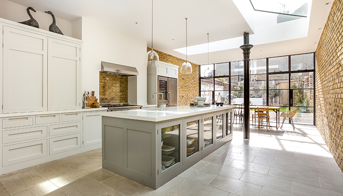 Painted in Little Greene French Grey Pale and Lead Colour, this light and airy handleless Shaker kitchen is by Higham Furniture