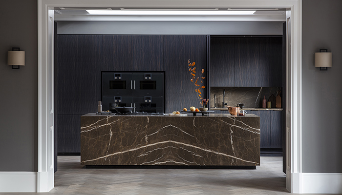 This stunning kitchen offers the client the option to conceal the sink area behind pocket doors, and features Eggersman’s cabinetry in Maro Ebony, a composite wood with embossed, grain-like texture. The island is encased in Coffee Brown Marble