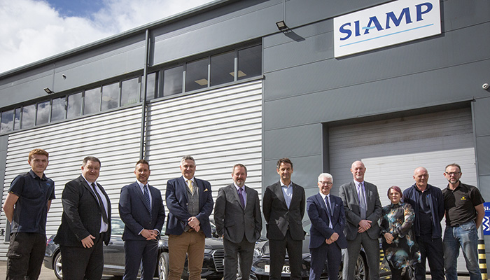 Ashley Shires, MD of SIAMP UK, fifth from left, and Thierry Leroy, CEO of SIAMP, centre, at the official opening of the new HQ in Stockport