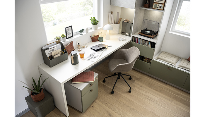 In this contemporary open-plan design from Schmidt, the office is separated from the kitchen and living room by on open storage unit. Creating an L-shaped run, the desk is complemented by Mossa Green and Stone Grey open shelves and drawers, which also feature on the window seat