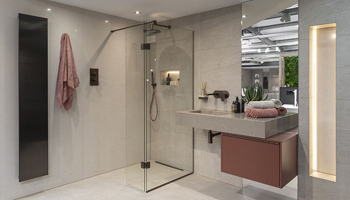 This bathroom features a fixed shower screen with brushed bronze Abacus brassware. The wall mounted vanity unit is from Leicht's Le Corbusier range and has a l’ocre rouge matt finish. It is teamed with a bespoke Silestone basin. The Bisque brushed bronze Artiplano vertical radiator finishes off the design
