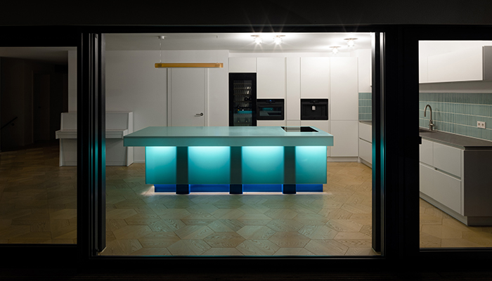 This backlit island from HIMACS is a stunning example of craftsmanship made from Emerald, a translucent material from their Lucent Collection. The counter’s lower inner structure comprises large steel tubes that can be seen when backlit, and a base made of powder-coated blue steel