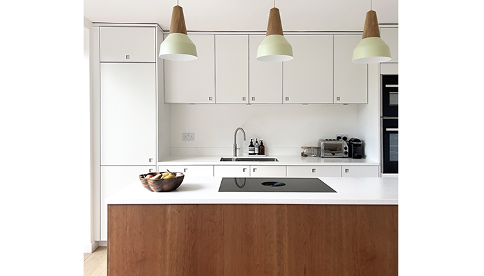 These pared-back cupboards in Half Moon White with Cherry wood are by Pluck, and create an uncluttered style with recessed handles. The client’s brief was a 'light and muted design'. The designer used the room’s natural light to maximum effect and the wood surround on the island brings warmth and texture