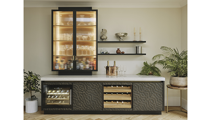 In the Hackney kitchen, a home bar with illuminated fluted glass cabinet, wine rack and wine cabinet is situated next to the dining area