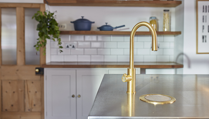Featuring a swan-neck design, the Zip HydroTap Arc Plus is seen here in brushed gold