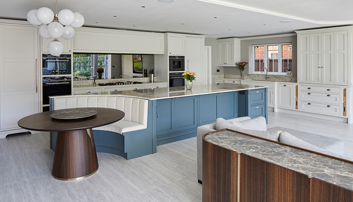 The built-in bench in this in-frame Shaker kitchen, which features Sheraton Interiors’ Bespoke Collection, wraps around the table at the end of the island, seamlessly linking the dining and kitchen areas together