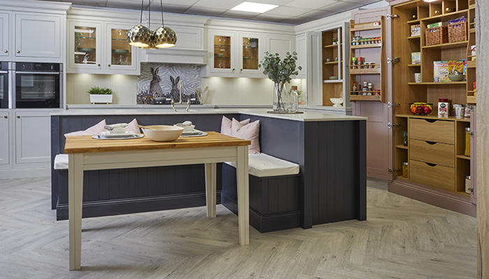 The L-shaped island within this design in LochAnna Kitchen’s showroom features integrated bench seating to create a functional and comfortable dining area 