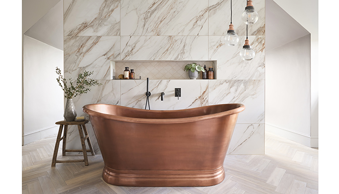 BC Designs’ Antique Copper Boat Bath adds a touch of spa-style to this open-plan bedroom/bathroom, which was designed by Ripples Solihull. Marble-effect tiles, black brassware and pendant lights complete the look