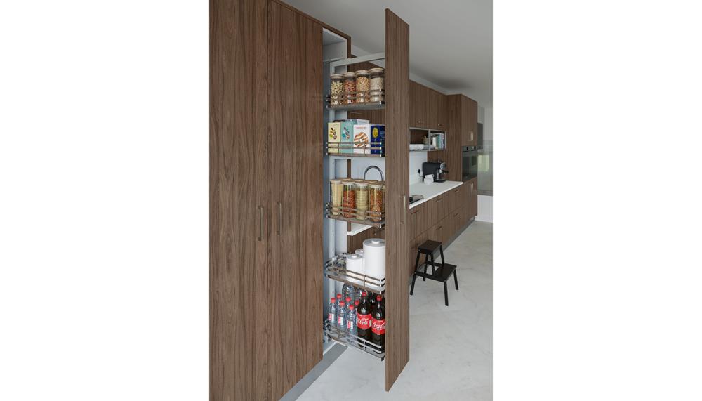 Crown Spaceworks+ larder pull-out solution is shown here in Textura Walnut natural featuring 150mm pull-outs, corner storage, and integrated waste bins. These versatile, soft-close options are available across Crown&rsquo;s kitchen ranges