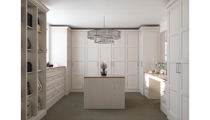 An elegant, more traditional dressing-room style from PWS with matching panelled doors and drawers, integrated vanity area and island unit from the Mornington Beaded collection in Cashmere
