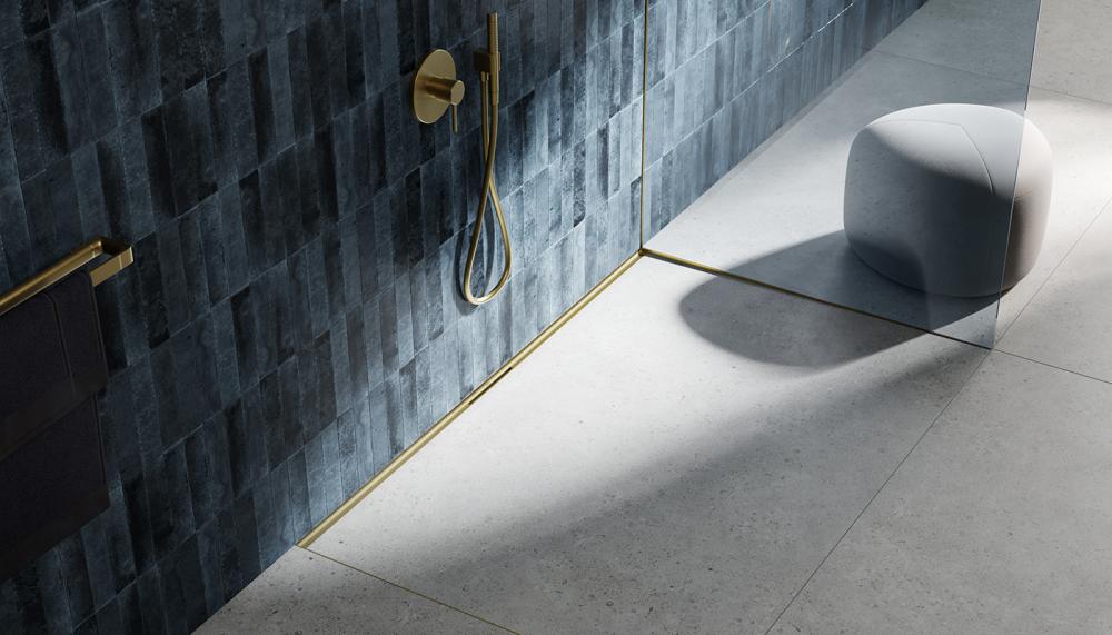 The new TECEdrainway ultra-narrow drain in Brushed Brass finish, TECE