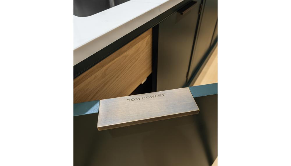 The edge-pull handle wraps around and is inset into the door, without visible fixings