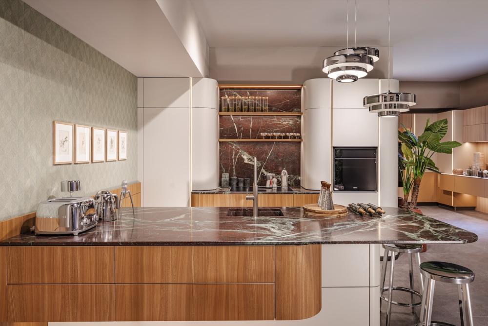 Sachsenk&uuml;chen's new SoftArc concept was introduced to retailers through a stunning selection of lifestyle roomsets, including a contemporary two-tone Fabiola booked-matched veneer and Selma kitchen scheme