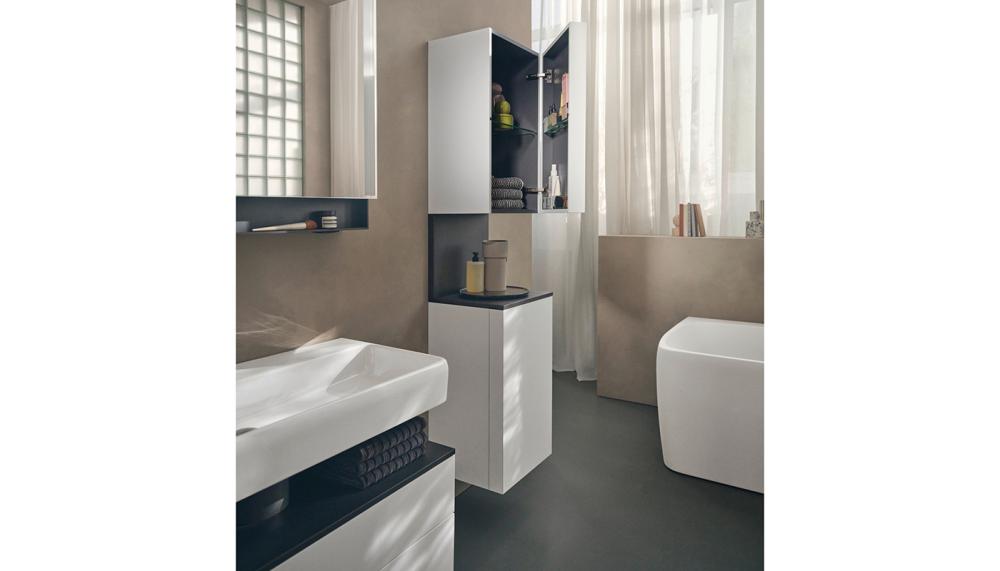 The tall cabinet with case door follows the design of the washing area through consistently: inside it ensures tidiness, while a vertical niche in anthracite on the outside sets a clear tonal counterpoint