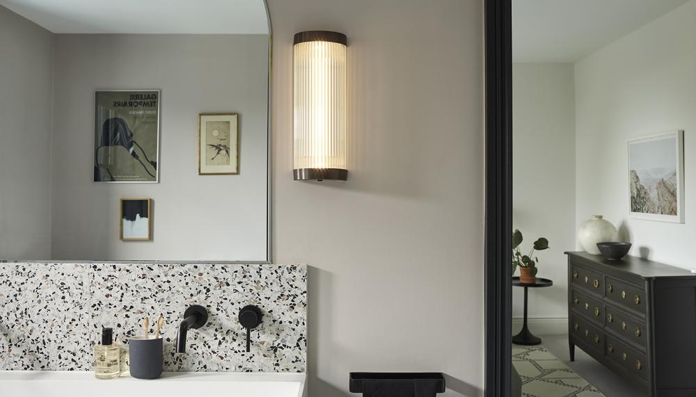 The Art Deco-inspired Wide Pillar Wall Light features a curved profile made of 8mm diameter solid glass rods. Made in the UK by Davey Lighting, it is available in two sizes: 40cmH x 15cmW or 60cmH x 15cmW and comes in a weathered brass, pictured, chrome or polished brass finish