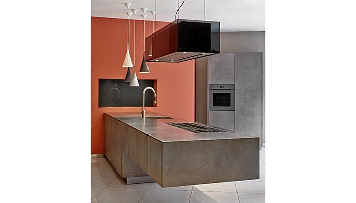 Eggersmann Concrete cantilevered island topped with Barazza stainless steel worktop and gas hob, finished with a Novy extractor above