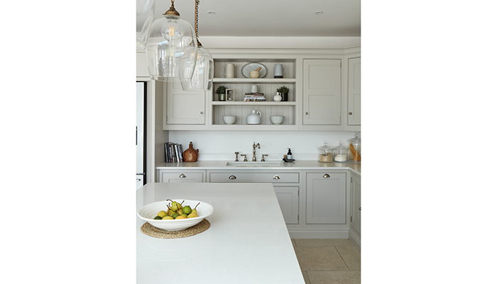 A traditional-style kitchen designed by Tom Howley using The Hartford collection painted in paler off-white Tansy and Nightshade with a complementary Caesarstone Organic White worktop creating an elegant look