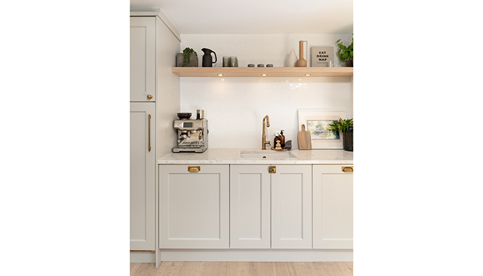This scheme designed by Jones Britain featuring Masterclass Kitchens uses contrasting textures to add warmth and depth to this kitchen with Ashbourne Highland Stone cabinetry, high-gloss metro tiles and open Portland Oak shelving with recessed lighting