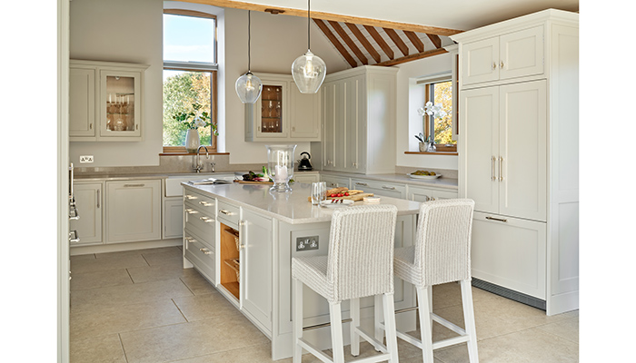 Simon Taylor Furniture used Cornforth White – a pale neutral grey – on all the cabinetry to contrast with the natural oak beams with a complementary quartz worktop in Clamshell by Caesarstone.  Photo: Nick Smith.
