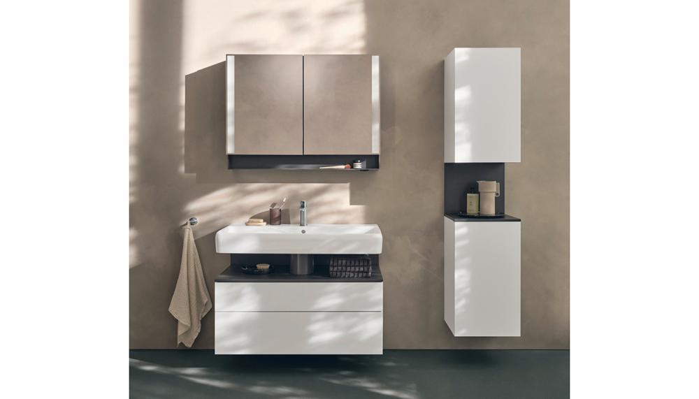 The washing area forms the centrepiece, making a bold statement with its clear design language and interplay of white and anthracite. An anthracite-colored niche cuts between the generously proportioned ceramic washbasin and white drawers to lend the ensemble depth and character