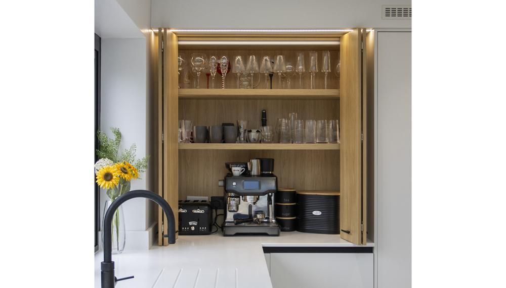 Masterclass Kitchens&rsquo; country-style dresser in Portland Oak with matching Ligna Portland Oak bi-fold door is an ideal multifunctional countertop drinks station &ndash; a great solution for a smaller kitchen