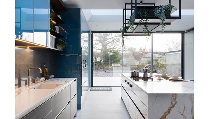 The Garden Room leads to a back garden through sliding glazed doors, with a view to Winchester Cathedral. The sink run includes a Dekton-clad Axixuno sink by 1810 Company with a Quooker Fusion square tap in stainless steel finish
