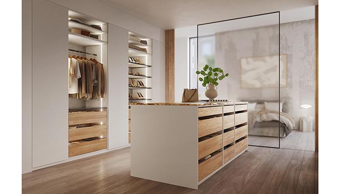 Rotpunkt’s Zerox FM Beach Grey & Tessuto dressing-room with statement island drawer unit and contemporary shelving provides extra storage space to display fashion accessories, available in either wood or glass finish option with smart-ready continuous vertical LED lighting 