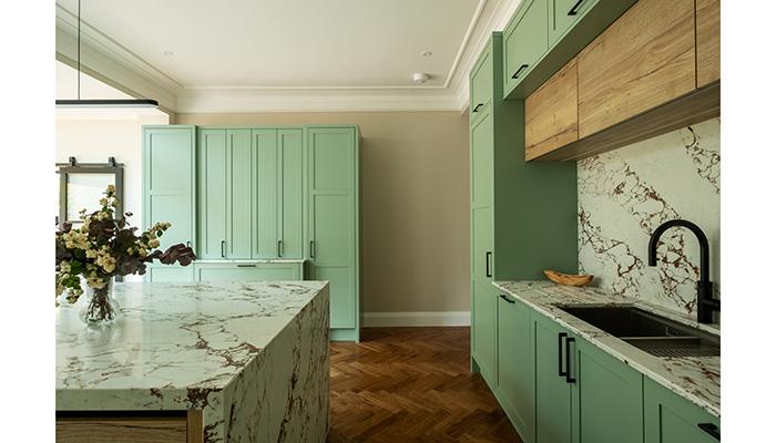 Callerton's Balham 58 kitchen features a custom soft green painted finish paired with Abstract Expressions in Natural Halifax Oak and a striking veined worktop. The simplicity of the skinny Shaker frame allows for bolder colour and material choices, resulting in a calm yet characterful space