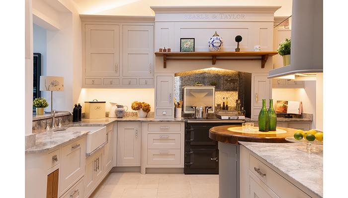 On the mezzanine level is an extra-height Classic Bespoke kitchen display painted in Manor House Grey by Farrow & Ball with an Everhot range cooker under the canopy. The farmhouse sink is by Villeroy & Boch