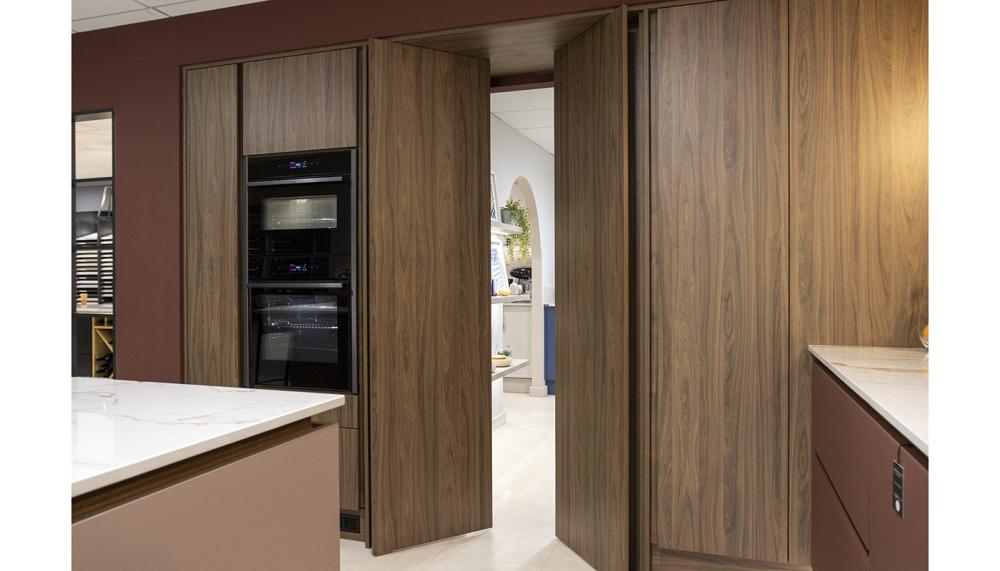 This scheme by Ratford Bridge featuring Masterclass Kitchens doors in Tuscan Walnut shows how cleverly concealed elements can bring real flexibility to an interior